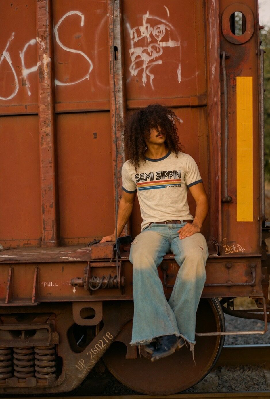 A ringer tee, navy trim, on the coupling of a freight car